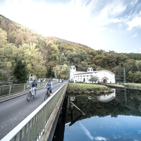 Cyclists on the bridge to the Heimbach art nouveau power station, © Dennis Stratmann | Grünmetropole e.V. Cyclists on the bridge to the Heimbach art nouveau power station, © Dennis Stratmann | Grünmetropole e.V.