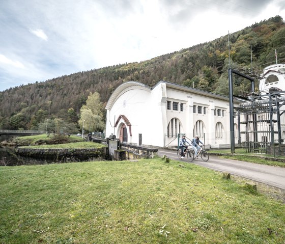 Cyclists at the art nouveau power station in Heimbach, © Dennis Stratmann | Grünmetropole e.V. Cyclists at the art nouveau power station in Heimbach, © Dennis Stratmann | Grünmetropole e.V.