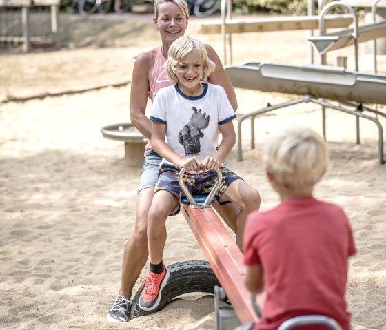 Familie auf dem Spielplatz im Kurpark Heimbach, © Dennis Stratmann | Grünmetropole e.V. Familie auf dem Spielplatz im Kurpark Heimbach, © Dennis Stratmann | Grünmetropole e.V.