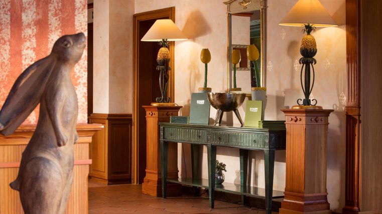 Ein stilvolles Interieur mit einem Holzläufer und warmem Licht. Eine elegante Kommode mit Dekoration und Lampen zieht die Aufmerksamkeit auf sich.