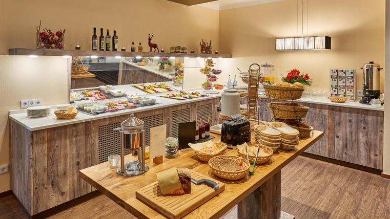 Ein ansprechend gedeckter Frühstückstisch mit verschiedenen Speisen und Getränken. Das Buffet ist klar strukturiert und lädt zum Schlemmen ein.