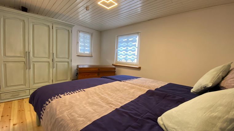 Ein gemütliches Schlafzimmer mit einem großen Bett und hellen Wänden. Der Raum ist gut beleuchtet und verfügt über einen Kleiderschrank und ein Fenster.