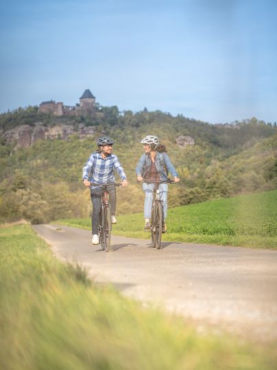 Radfahrende auf dem RurUfer-Radweg vor Burg Nideggen