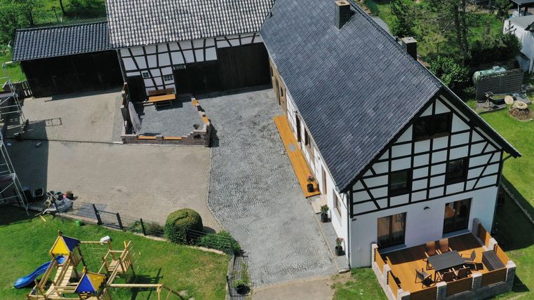 Ein schönes Bauernhaus mit einem großen Garten und einem Spielplatz. Die Terrasse lädt zum Entspannen im Freien ein.