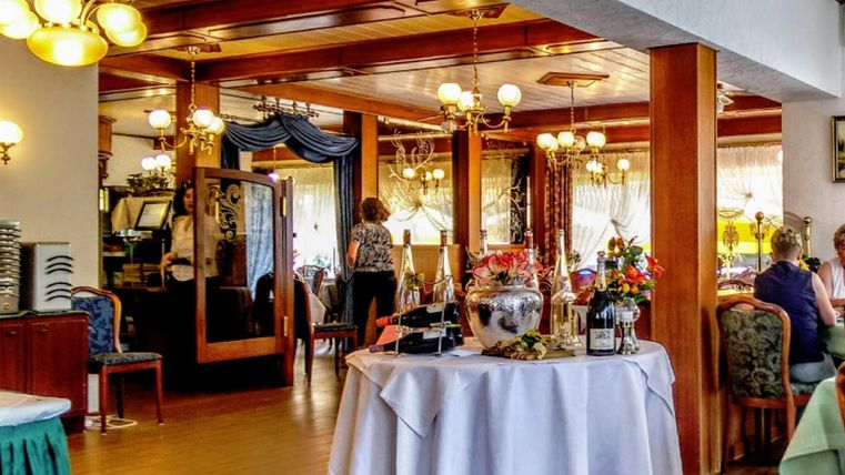 Ein gemütliches Restaurant mit eleganter Einrichtung. Tische sind dekoriert und die Atmosphäre ist einladend.