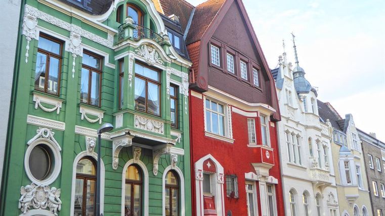 Bunte historische Gebäude in einer Stadtstraße. Die Architektur zeigt verschiedene Stile und Farben.