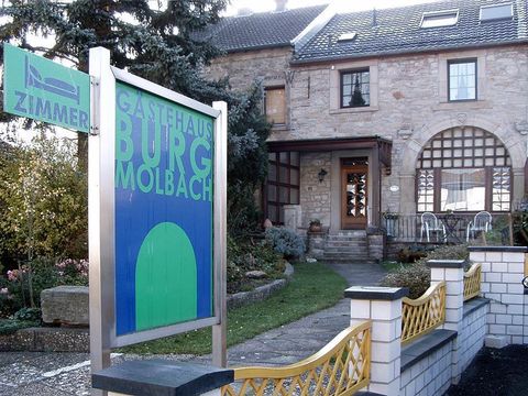 Ein charmantes Gästehaus mit dem Namen „Burg Molbach“. Es ist von einem schön angelegten Garten umgeben.