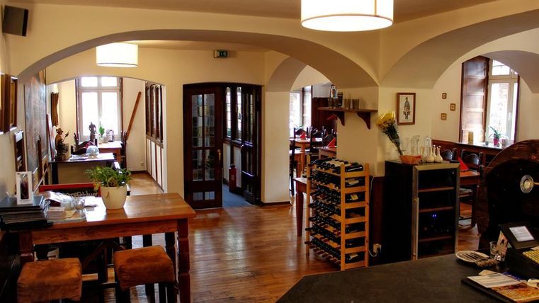 Ein gemütlicher Innenraum eines Restaurants mit Holzdetails und einer Weinschrank. Die warmbeleuchtete Atmosphäre lädt zum Verweilen ein.