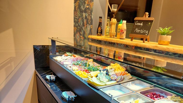 Ein Buffet mit einer Auswahl an frischem Obst, Rohkost, Aufschnitt und Käse.