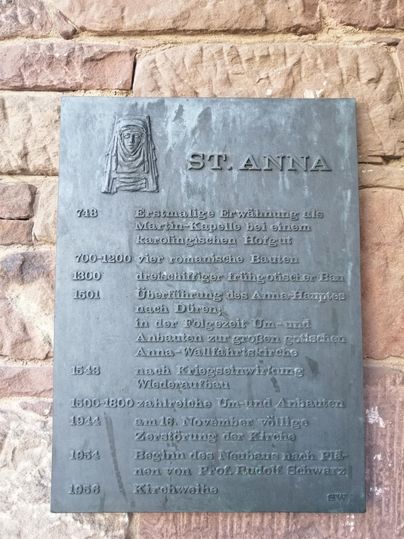 Eine informationsreiche Gedenktafel über St. Anna mit historischen Daten und Ereignissen. Die Tafel enthält wichtige Informationen zur Geschichte und Bedeutung des Ortes.