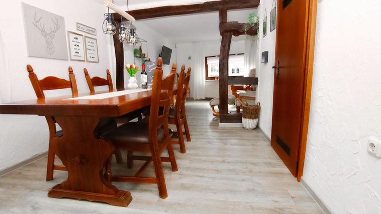 Ein einladender Essbereich mit einem großen Holztisch und Stühlen. Der Raum hat eine helle Atmosphäre mit Holzdetails und angenehmer Dekoration.
