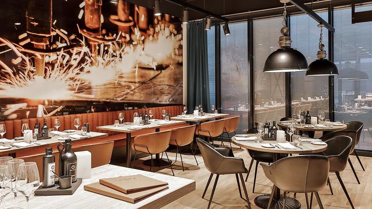 Ein modernes Restaurant mit stilvollen Möbeln und einer beeindruckenden Wanddekoration. Die Atmosphäre ist einladend und gemütlich.