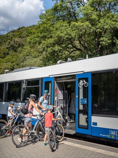 Familie mit Fahrrädern beim Einsteigen in die Rurtalbahn