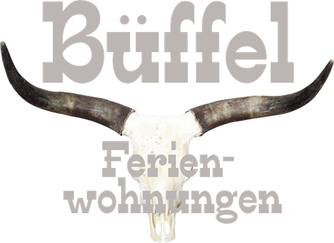 Ein Tierkopf mit großen Hörnern, der als Dekoration dient. Darunter steht der Schriftzug "Büffel Ferienwohnungen".