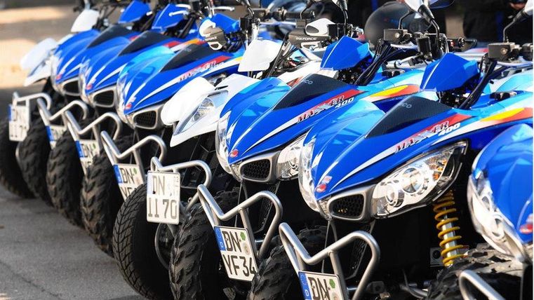 Eine Reihe von blauen Quads steht ordentlich aufgereiht. Die Fahrzeuge sind bereit für ein aufregendes Abenteuer.
