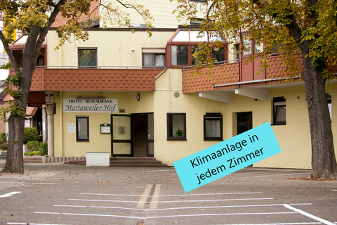 Ein Hotelgebäude mit dem Namen "Maranwiler Hof". Es gibt Werbung für Klimaanlagen in jedem Zimmer.