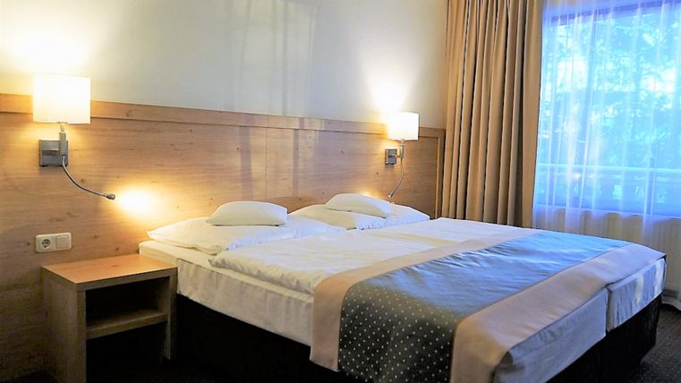 Ein gemütliches Zimmer mit zwei Betten, einem Schreibtisch und einem Fernseher. Das Ambiente ist schlicht und einladend, ideal für einen entspannenden Aufenthalt.
