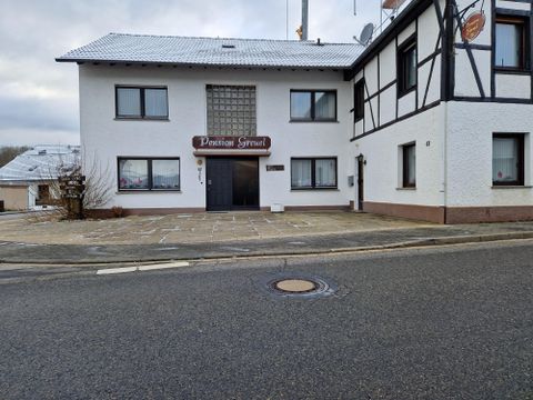 Ein Gasthaus mit dem Namen "Pension Serwe" an einer ruhigen Straße. Das Gebäude hat einen weißen Außenanstrich und ein traditionelles Satteldach.