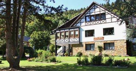 Ein schönes Haus im ländlichen Stil mit einem Garten. Umgeben von Bäumen und grüner Natur.
