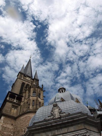 Eine beeindruckende Architektur mit einer hohen Kirche und einer auffälligen Kuppel. Der Himmel ist von vielen Wolken durchzogen.