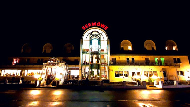 Ein beleuchtetes Gebäude mit dem Namen "Seemöwe" in der Nacht. Es hat eine moderne Architektur und eine einladende Atmosphäre.