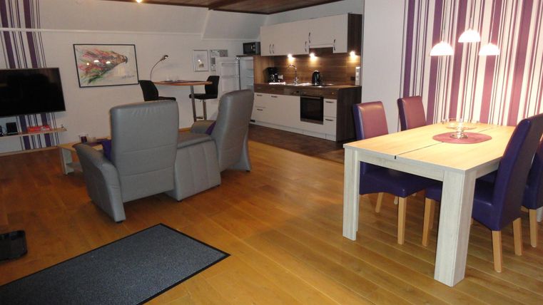 Eine moderne Wohnung mit einer offenen Küche und einem gemütlichen Wohnbereich. Der Raum ist gut beleuchtet und hat eine einladende Atmosphäre.